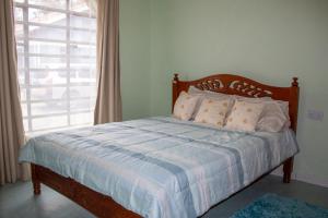 a bedroom with a bed with a blue and white blanket at Ziwa View Apartments in Goat Island