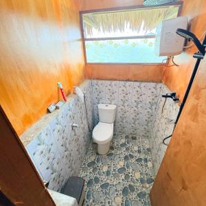 a small bathroom with a toilet and a window at Rumsram Homestay by Rumah Etnik Papua Sorong in Papermaranda +12 photos