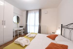 ein Schlafzimmer mit einem großen weißen Bett mit Handtüchern darauf in der Unterkunft Residence Il Patio in Iseo