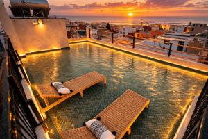 a swimming pool on a cruise ship at sunset at Surf Lodge Tamraght in Tamraght Ouzdar