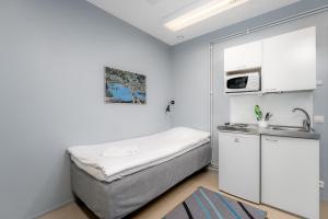 a small room with a bed and a sink at Jääskän Loma Hostelli Antin Tupa in Härmä