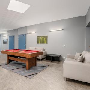 a living room with a ping pong table and a couch at Jääskän Loma Hostelli Antin Tupa in Härmä