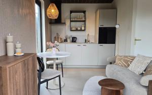 a living room with a couch and a table at Luxe Tiny Suite met privé tuinbad in Meerssen