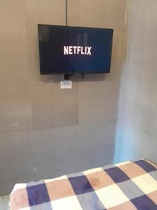 a television on a wall with a netflix sign on it at Residence 168 in Gununganjar