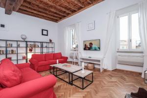 ローマにあるTrastevere Premium Apartmentのリビングルーム(赤いソファ、テレビ付)