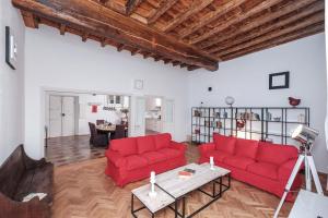 ローマにあるTrastevere Premium Apartmentのリビングルーム(赤いソファ2台、テーブル付)