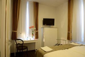 ein Schlafzimmer mit einem Bett und einem Stuhl und einem Fenster in der Unterkunft Landhotel Alte Töpferei in Duisburg