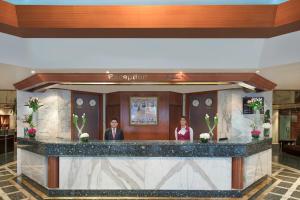 two people standing at a bar in a lobby at Admiral Plaza Hotel in Dubai