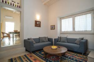 ein Wohnzimmer mit 2 blauen Sofas und einem Tisch in der Unterkunft Palazzo Degli Olivi in Modica