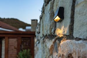 a light on the side of a stone wall at Villa Flam in Kholi