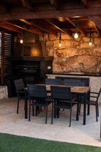 a kitchen with a table and chairs and a fireplace at Villa Flam in Kholi