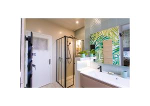 a bathroom with a sink and a shower and a mirror at Chez Fabienne et Olivier, chambre privative avec SDB et WC, Avranches Baie du Mont Saint Michel in Avranches