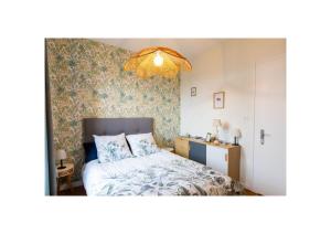a bedroom with a bed and a chandelier at Chez Fabienne et Olivier, chambre privative avec SDB et WC, Avranches Baie du Mont Saint Michel in Avranches