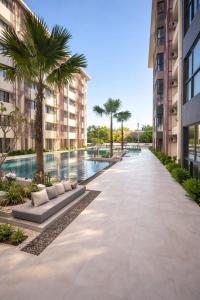 an empty walkway with palm trees and a swimming pool at Utopia Dream in Rawai Beach