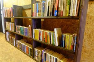 a book shelf filled with lots of books at はじまりの宿 ディール in Tsumagoi
