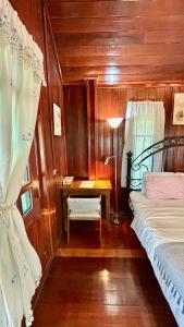 a bedroom with a bed and a desk with a lamp at Rang Robin Farmstay with swimming pool in Ban Wang Muang +17 photos