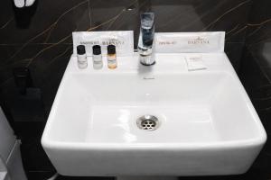 a bathroom sink with two bottles and a faucet at Barsana Suites in Vrindāvan +38 photos