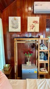 a room with a shelf with a vase of flowers on it at Rang Robin Farmstay with swimming pool in Ban Wang Muang