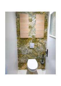 a bathroom with a toilet and a wall at Chez Fabienne et Olivier, chambre privative avec SDB et WC, Avranches Baie du Mont Saint Michel in Avranches