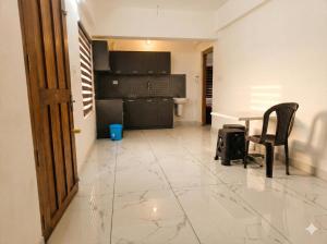 a room with a kitchen and a table and chairs at SAIS LINE Residency in Kozhikode