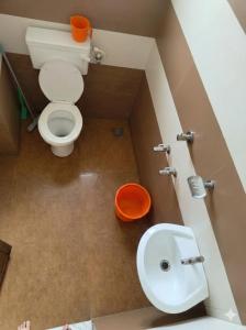 a small bathroom with a toilet and a sink at SAIS LINE Residency in Kozhikode