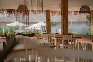 a restaurant with white chairs and tables and umbrellas at The Beach Resort in Koh Rong Island