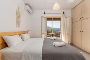 a bedroom with a large white bed with a view at Stay in Falassarna Rooms & Apartments in Falasarna