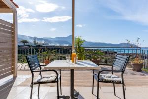 a table and chairs on a patio with a view of the ocean at Stay in Falassarna Rooms & Apartments in Falasarna +33 photos