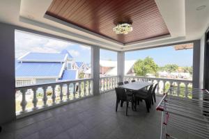 a dining room with a table and chairs on a balcony at Torres Farm Resort powered by Cocotel in Naic