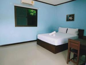 a bedroom with a bed and a window and a chair at ทิพ ทิพ รีสอร์ท ถ้ำเสือ in Ban Krabi Yai