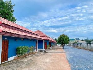 a blue building with a red roof on a street at ทิพ ทิพ รีสอร์ท ถ้ำเสือ in Ban Krabi Yai