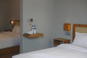 a bedroom with two beds and two bottles of water at The Umbu Stay Banyuwangi in Banyuwangi