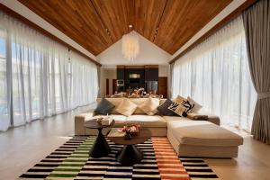 a living room with a couch and a table at Bougainvillea Luxury Pool Villas in Ban Pak Lak
