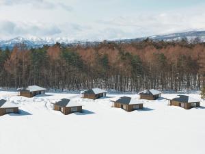 a group of cabins in a snow covered field at AZUMA FARM Koiwai in Shizukuishi