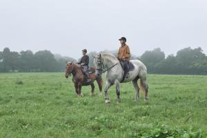 two people riding on horses in a field at AZUMA FARM Koiwai in Shizukuishi