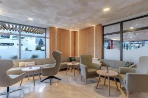 a waiting room with chairs and tables and windows at Hotel Victoriya in Kaprun +86 photos