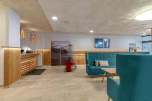 a waiting room with a blue couch and a table at Hotel Victoriya in Kaprun