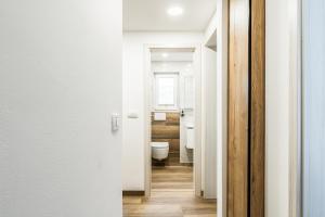 a bathroom with white walls and a toilet at Apartments CRYSTAL AURA in Bohinj +34 photos