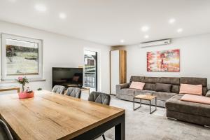a living room with a table and a couch at Apartments CRYSTAL AURA in Bohinj