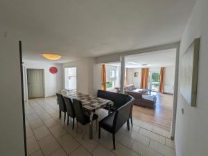 a dining room and living room with a table and chairs at zum Schilfrohr in Neuendorf