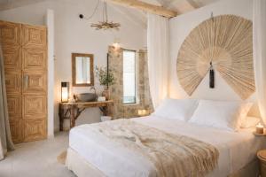 a bedroom with a white bed with a large wooden headboard at Spathes Luxury Private Pool Villa with Sea View in Kefalonia in Ratzaklíon