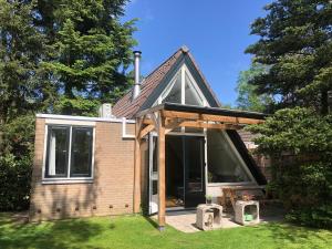 a small house with a large window on the grass at Rust in Voorthuizen +18 photos
