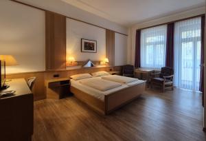 a hotel room with a bed and a desk at Villa Steiermark in Bad Reichenhall