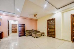 a living room with a couch and a ceiling at Super Townhouse HOTEL SPR ROAD in Gurgaon
