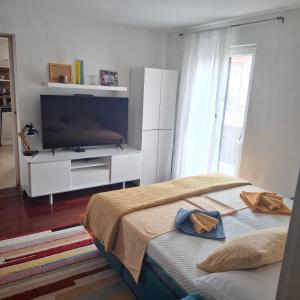 a bedroom with a television and a bed with two towels at Apartment Mamut in Premantura