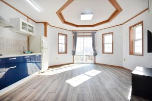 a large kitchen with wooden floors and windows at Taean Mong And Mong Pension in Taean