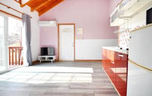 a kitchen with pink walls and a white door at Taean Mong And Mong Pension in Taean