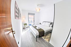a bedroom with a bed and a door leading into a room at Contemporary Chic with Terrace & Balcony in Madrid