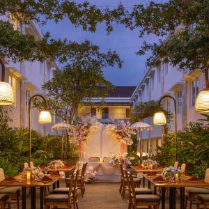 a restaurant with tables and chairs and lights at Crystalkuta Hotel - Bali in Kuta