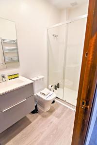 a white bathroom with a toilet and a shower at Contemporary Chic with Terrace & Balcony in Madrid